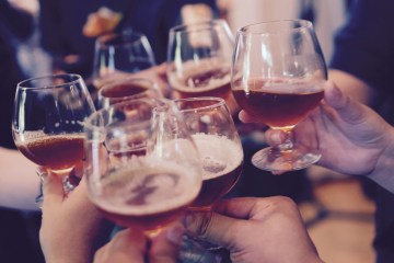 A group toast with beer tasting glasses
