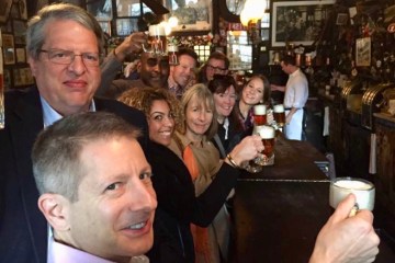A tour group having beer at a bar
